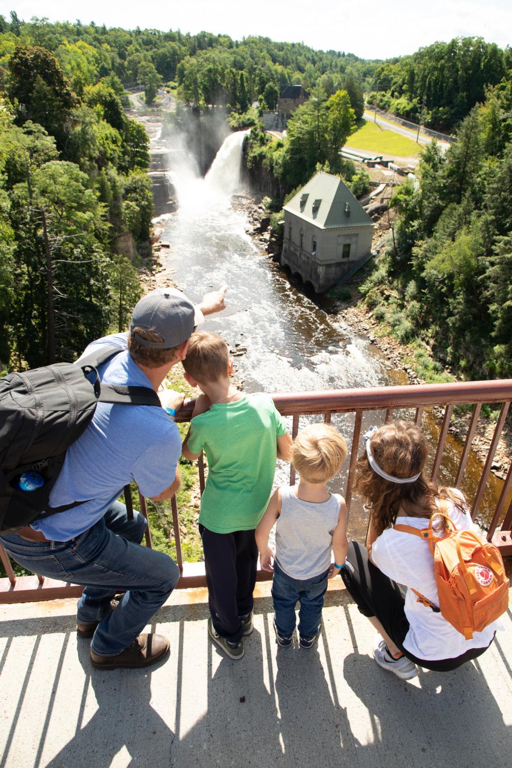 A man points to Ausable Chasm with his children.