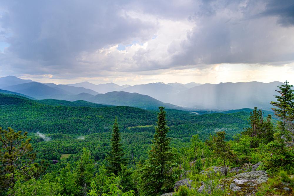 an aerial view of the green mountain range of Lake Placid in Summer.