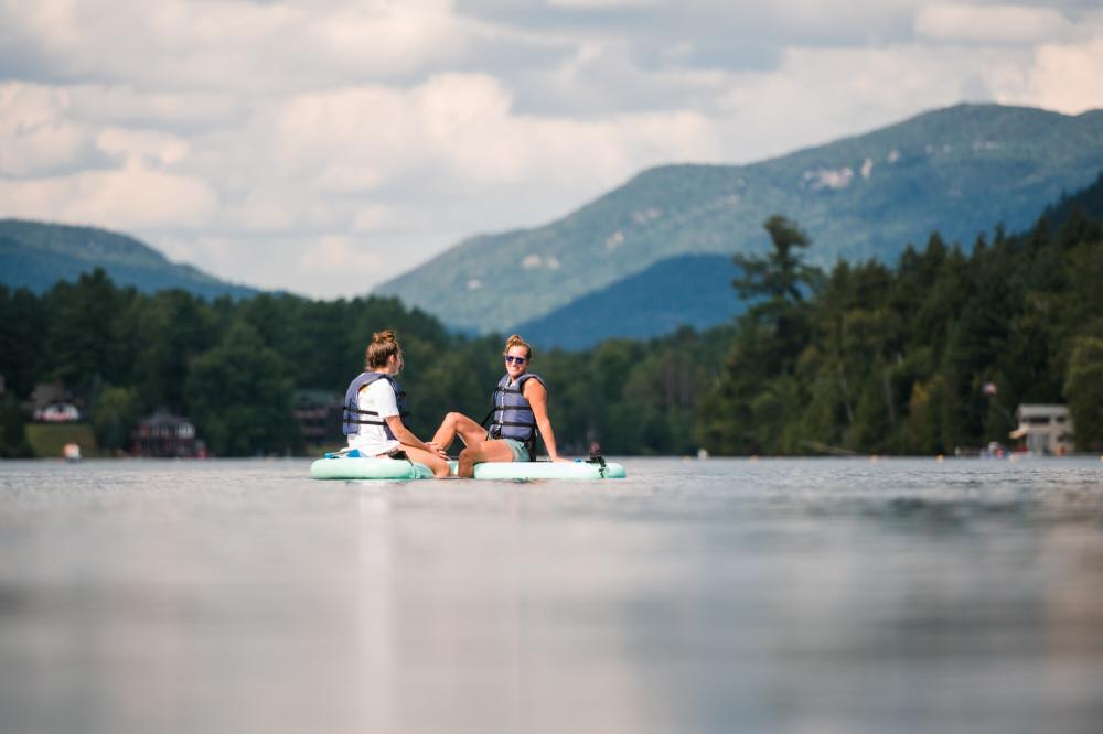 two women chat on SUPs in the middle of Mirror Lake.