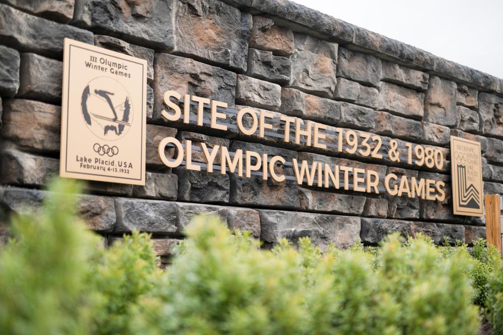 A stone and metal sign signifying the site of the 1932 and 1980 Winter Olympic Games