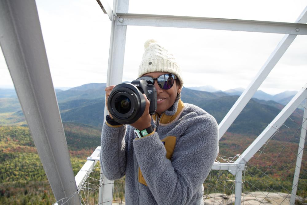 A woman takes a picture in a fire tower.