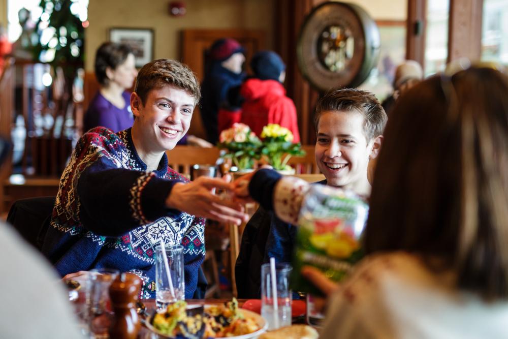 A family cheers drinks at dinner at a restaurant.