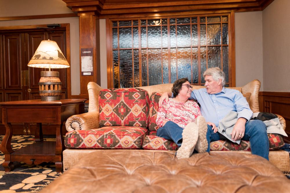 A couple relaxes on a couch in a luxury suite in one of Lake Placid's hotels