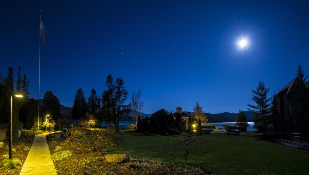 Whiteface Club grounds at night during a full moon, near a lake.