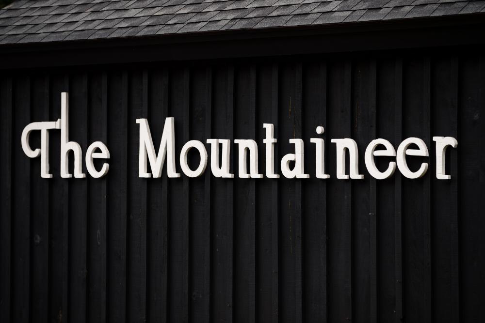 A white sign on a black background that says "The Mountaineer"