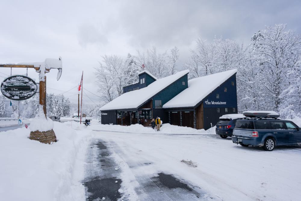 A few people walk into a snow-covered gear shop