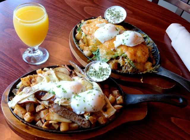 Two breakfast skillets served with orange juice.