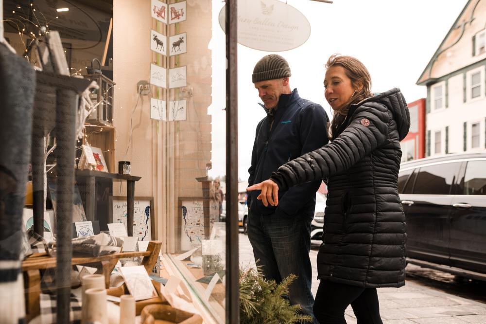 A man and woman window shop in winter.