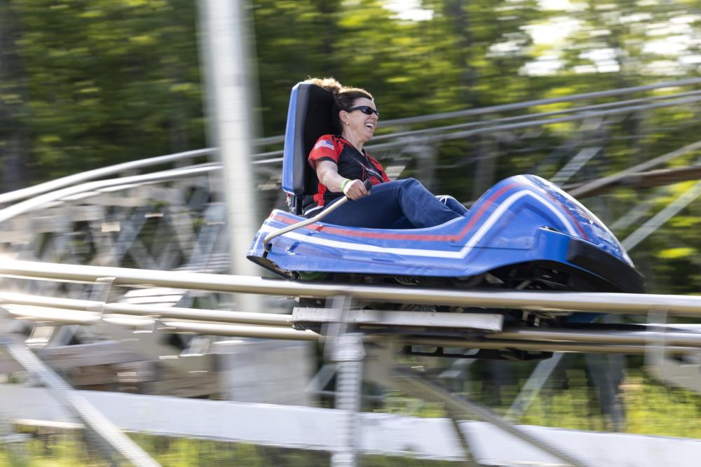 A woman speeds down a rollercoaster track in a cart.