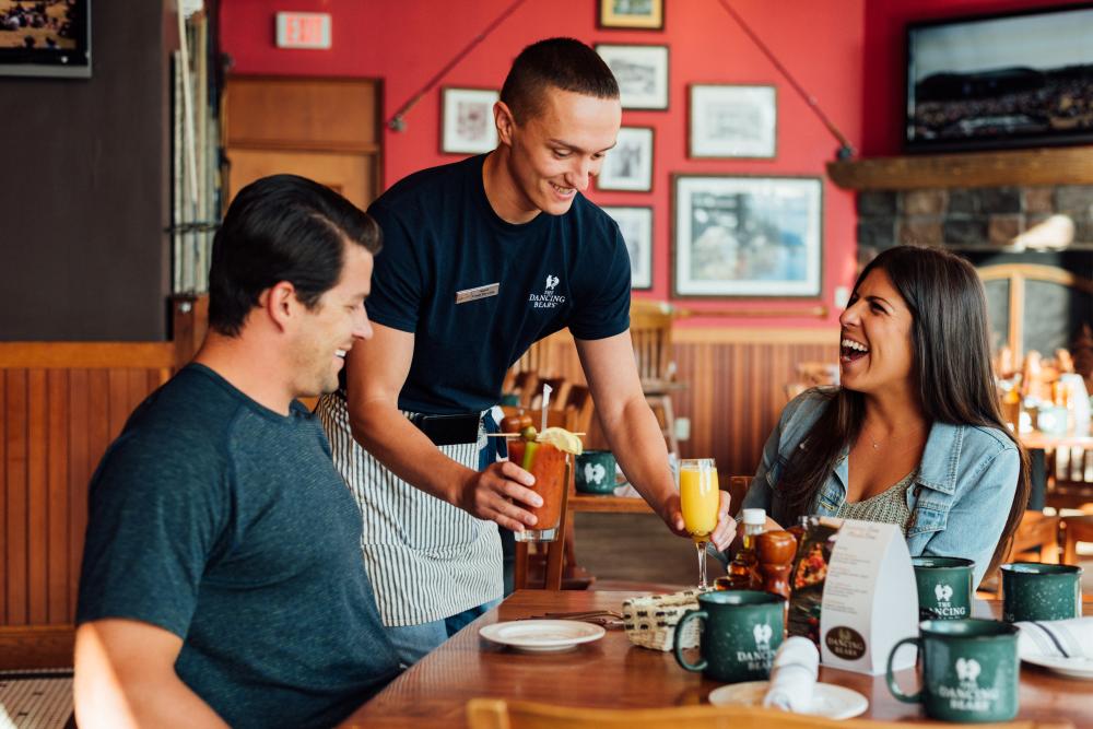 A man and woman order food at a cozy restaurant.