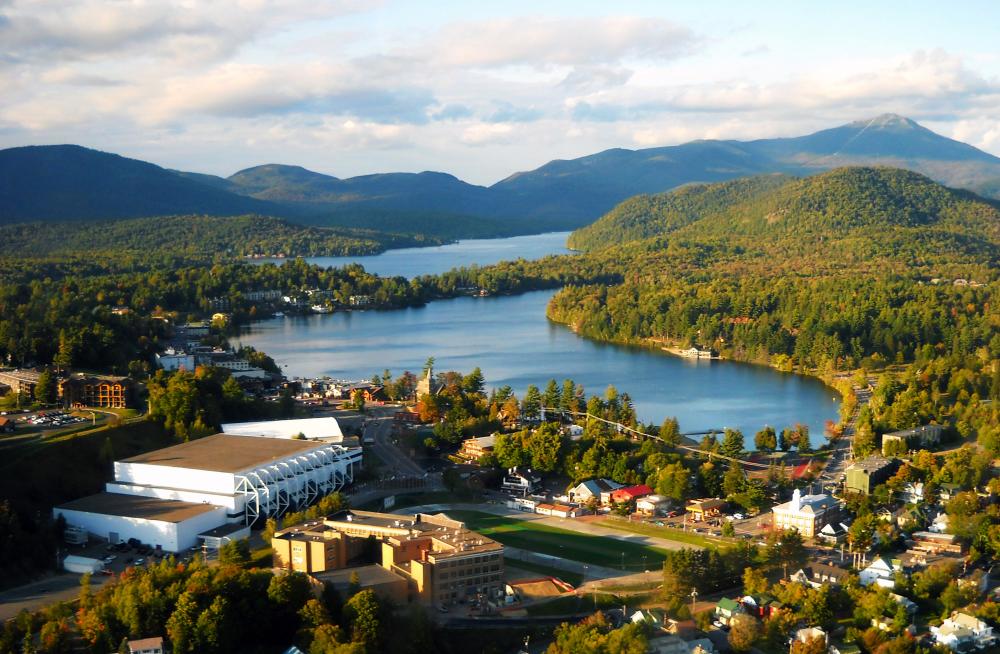 An aerial view of a town on a lake with wilderness around it.