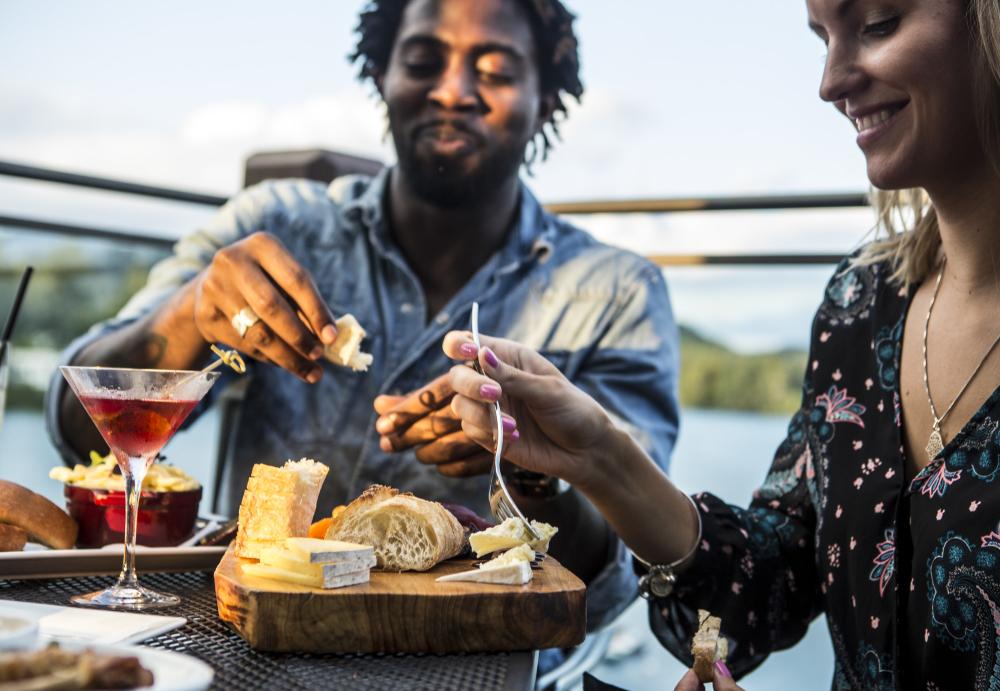 Couple enjoys cocktails and cheese board on deck