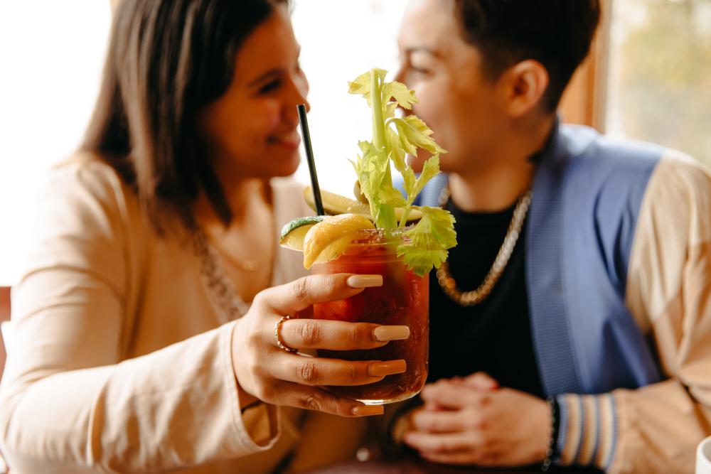 Couple holding up bloody mary in a jar