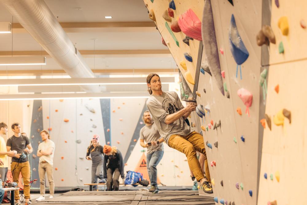 A large group of people bouldering in a climbing gym