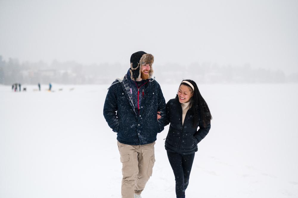 Walking on Mirror Lake Man and woman walk arm and arm on frozen lake in snowstorm
