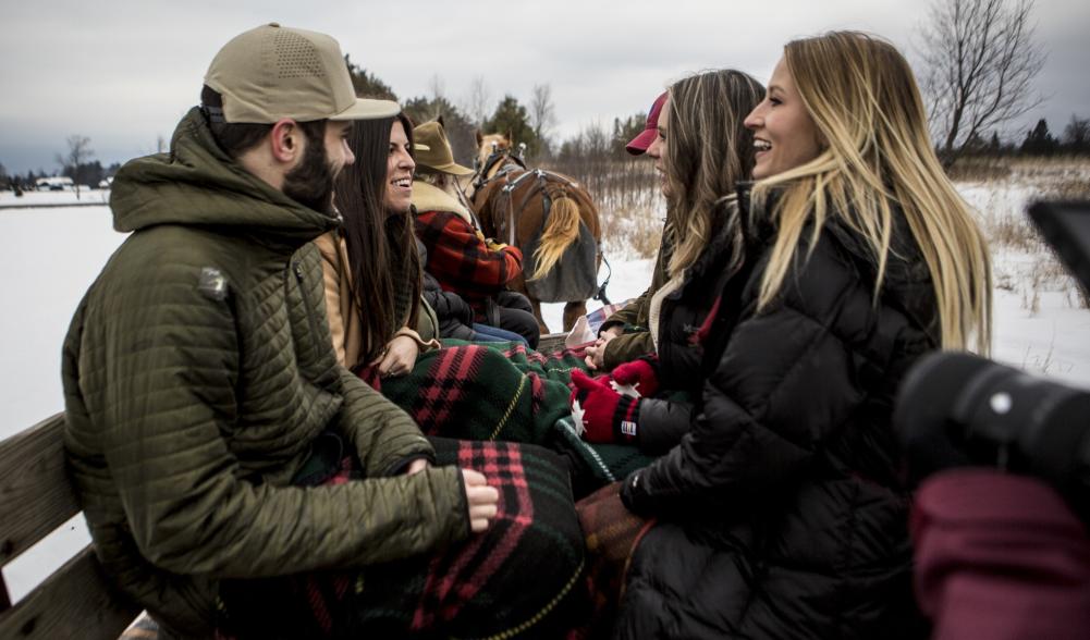 Group is cozy inside the wooden sleigh.