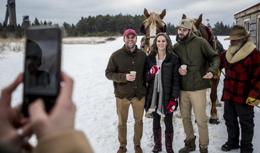 Group takes a photo in front of the sleigh.