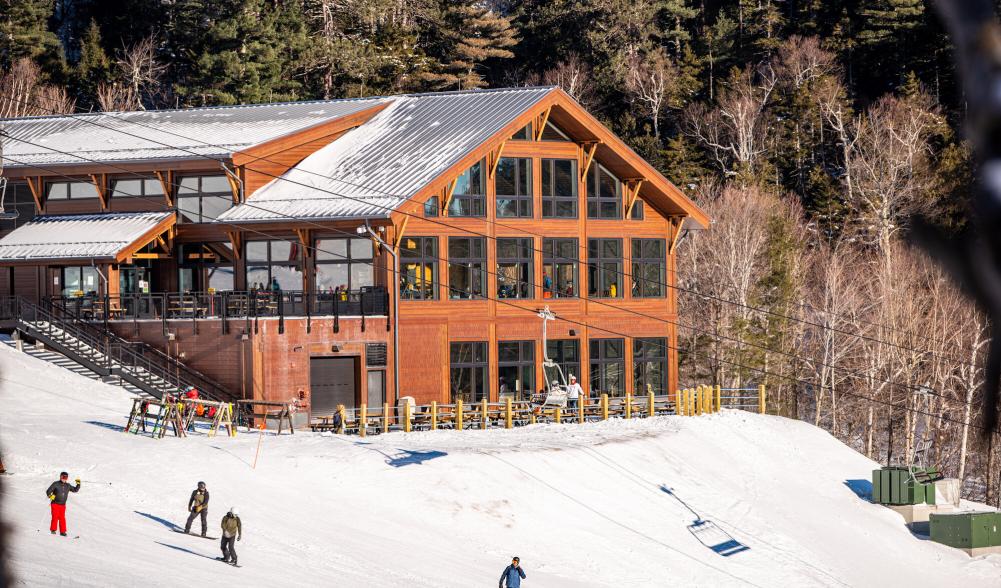 A brown nordic lodge sits on the side of Whiteface.