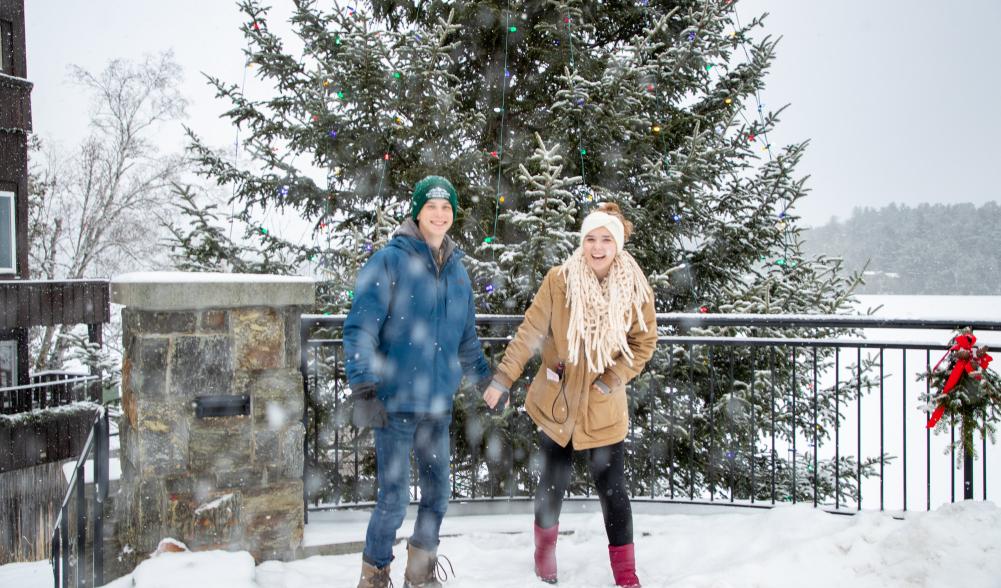 A couple walks around town on a snowy winter day