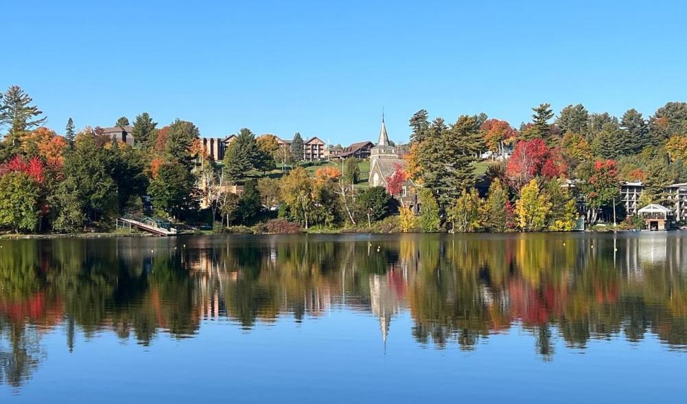 A view across the water of Mirror Lake during peak fall foliage