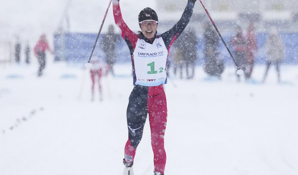 Athlete cheers as she crosses the finish line.