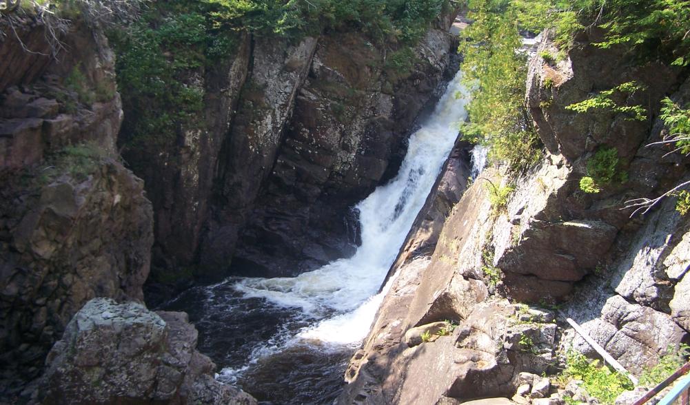 View of one of the waterfalls at High Falls Gorge from a suspended walkway above the Au Sable River.