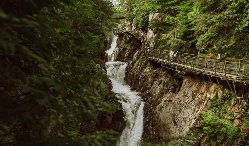 Suspended walkway hanging on the side of a cliff face above a series of waterfalls on the Au Sable River at High Falls Gorge