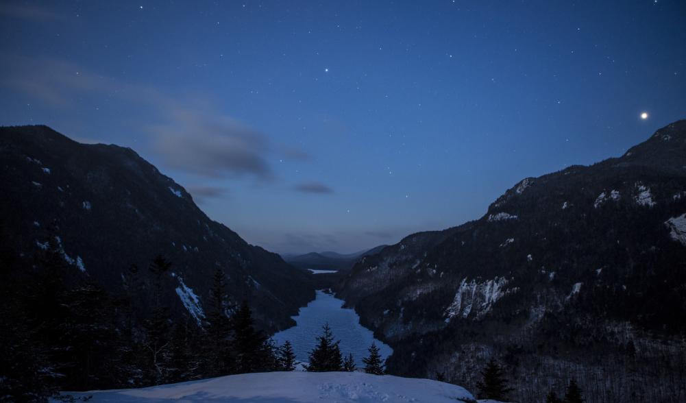 An early morning view of water and mountains atop a lookout