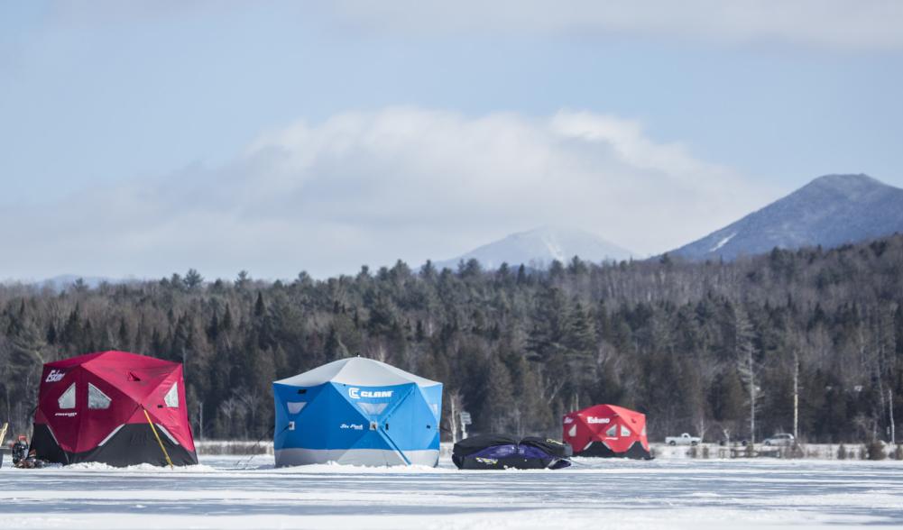 two men lead a sled back to their ice hut.