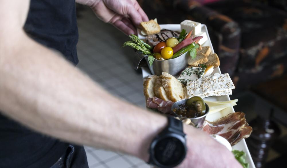 A close-up of a man holding a charcuterie board.