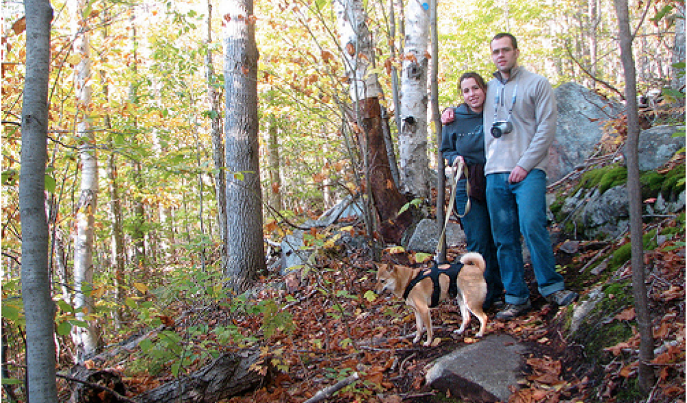 Couple hiking in woods with dog, Lake Placid, NY