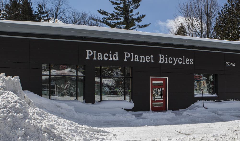 The front of Placid Planet Bicycles and it's snowy parking lot