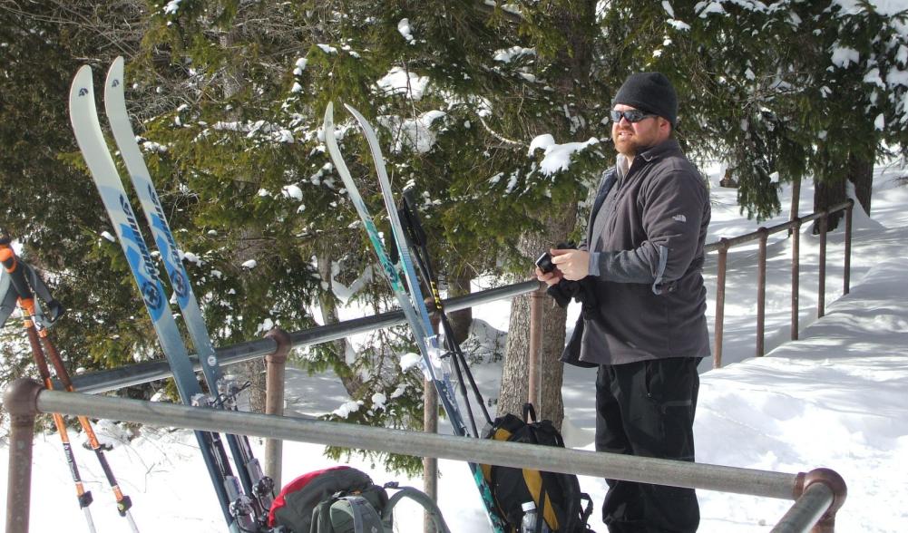 A man with cross-country skis at Marcy Dam