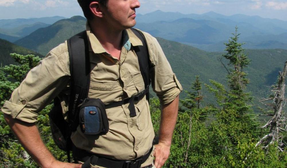 A man in beige clothes hiking in upstate ny