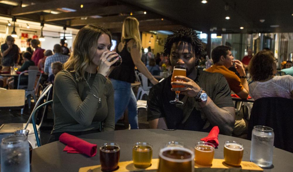 A man and woman sample beer in a busy Adirondack pub.