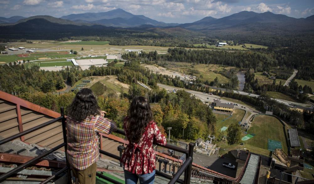 A young couple takes in the views from the top of one of the ski jumps in Lake Placid