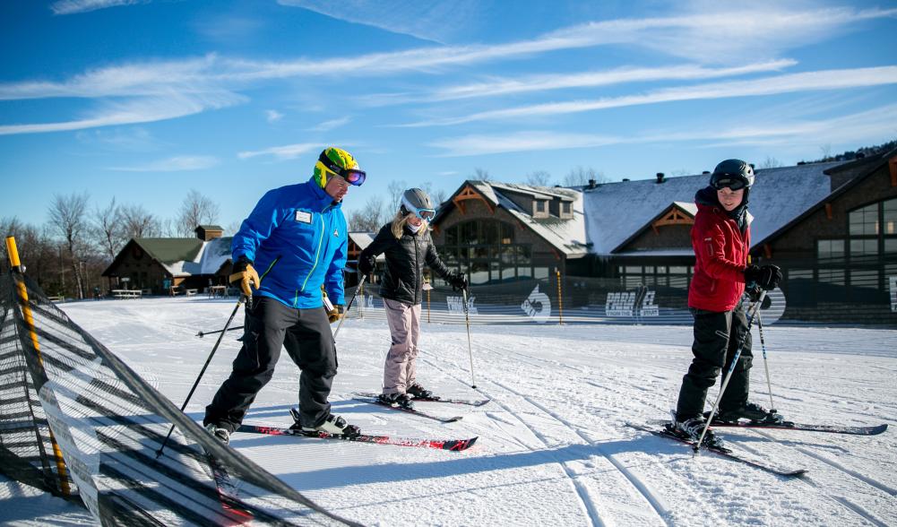 Two women taking a ski lesson with an instructor at Whiteface Mountain.