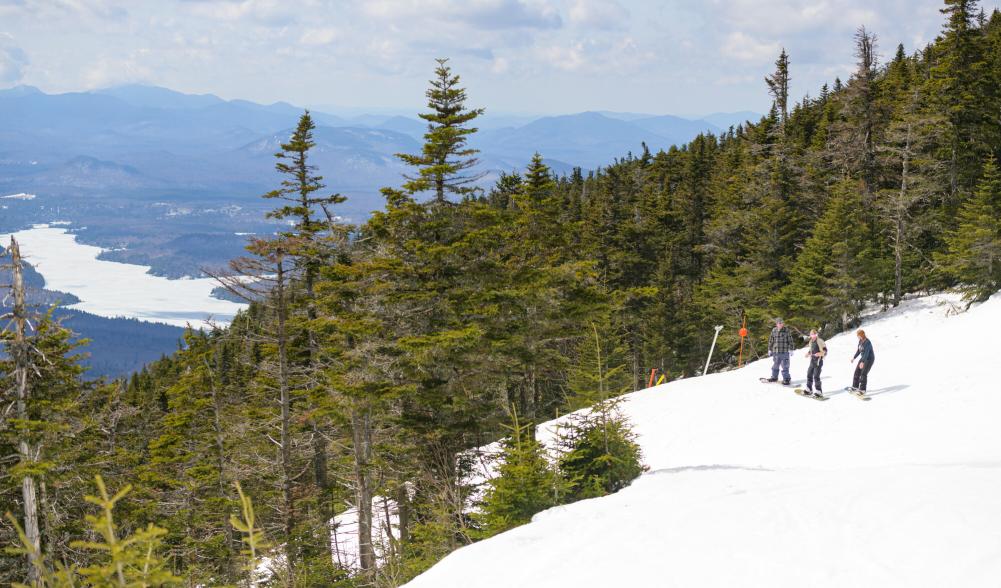 Skiers and snowboarders ready on a hill to ski and snowboard.