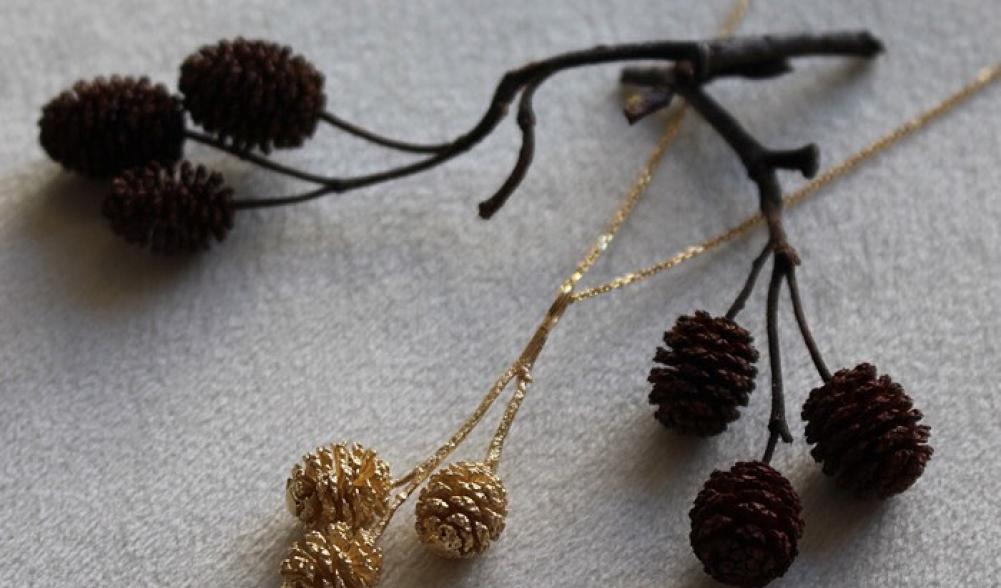 A delicate golden pinecone pendant, a sweet Adirondack souvenir.