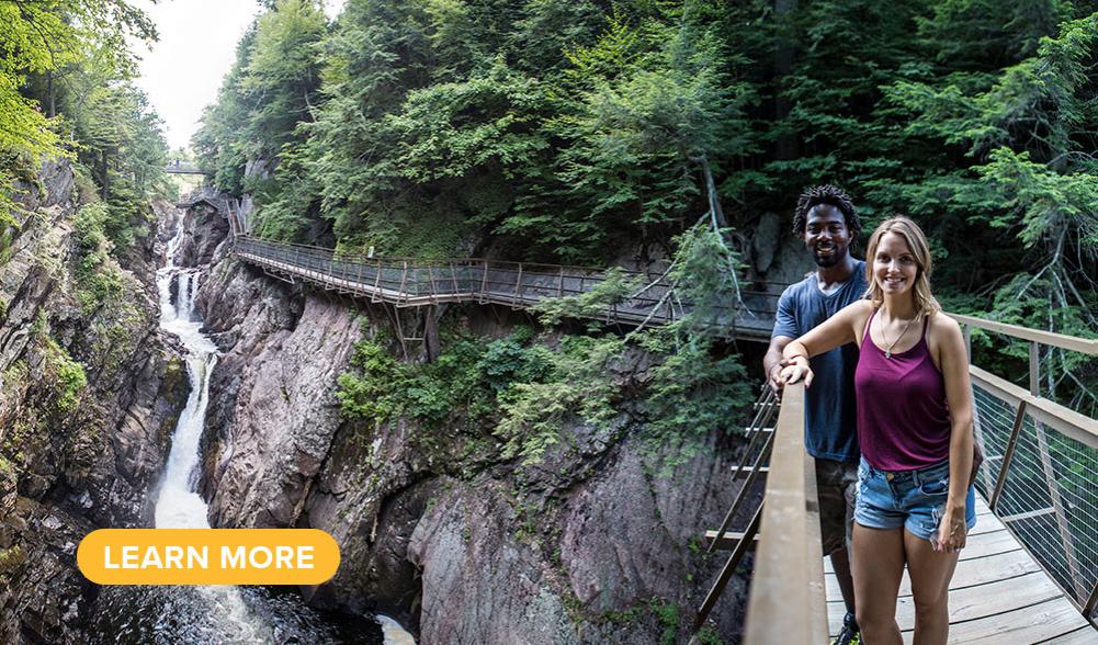 A couple poses on a footbridge crossing over High Falls Gorge.