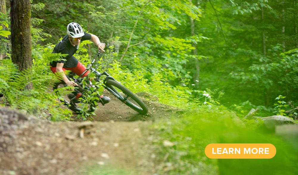 A mountain biker makes a turn on a wooded trail.