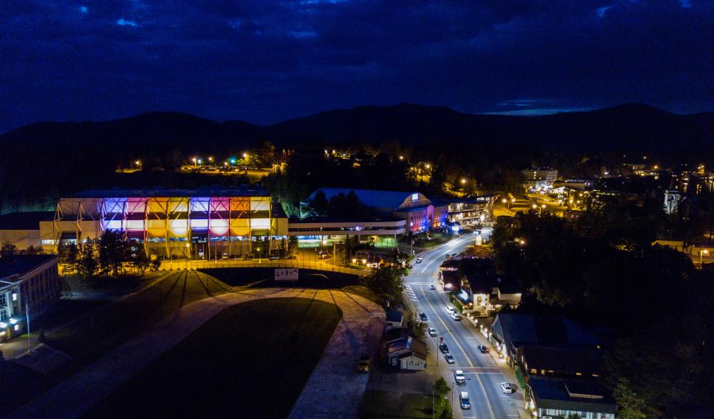 The Lake Placid Olympic Center buildings lit up at night.