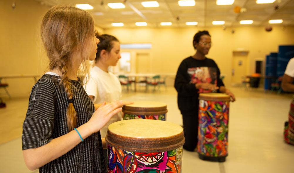 Three people in a bongo drum workshop.