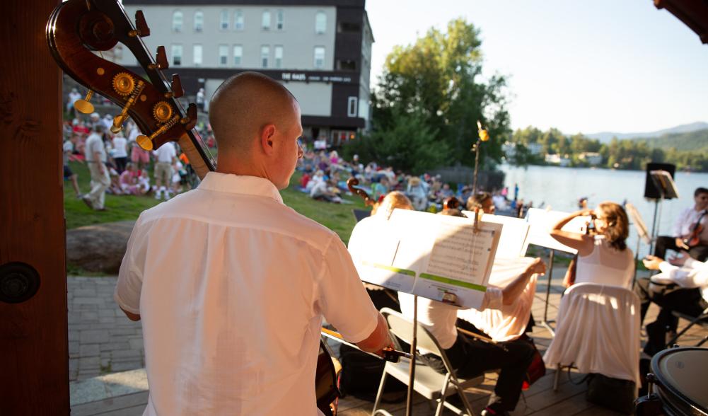 Orchestra musicians preforming with white shirts and black pants.