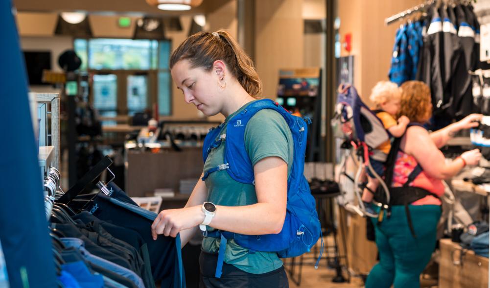 A woman shops at an outdoor gear shop.