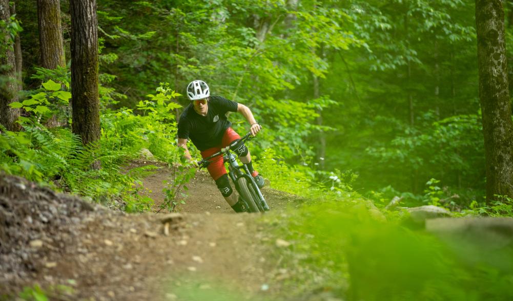 A man rides his mountain bike on a trail through the woods