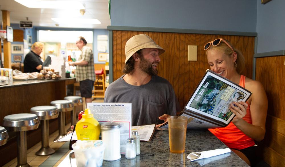 Two people look at diner menu