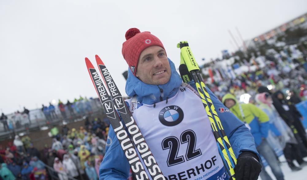 Tim Burke stands with skis and poles after race