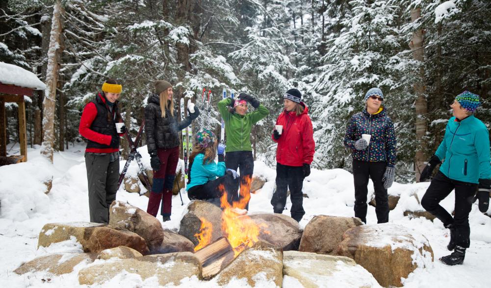 Group of women stand around fire in the snow