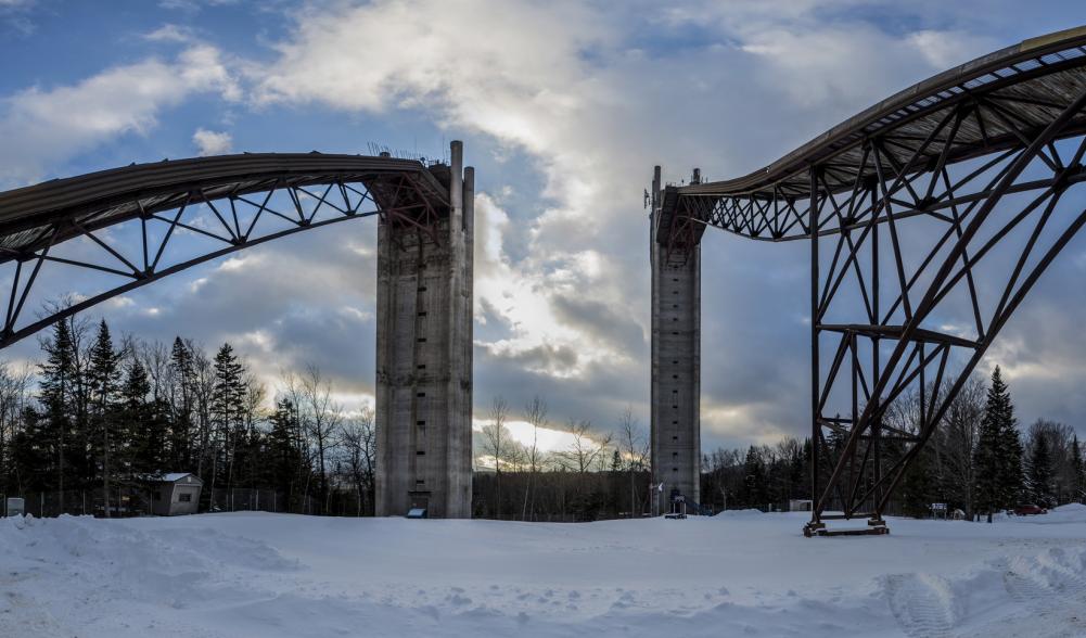 A wide view of the soaring Olympic ski jumps in Lake Placid on a snowy day.